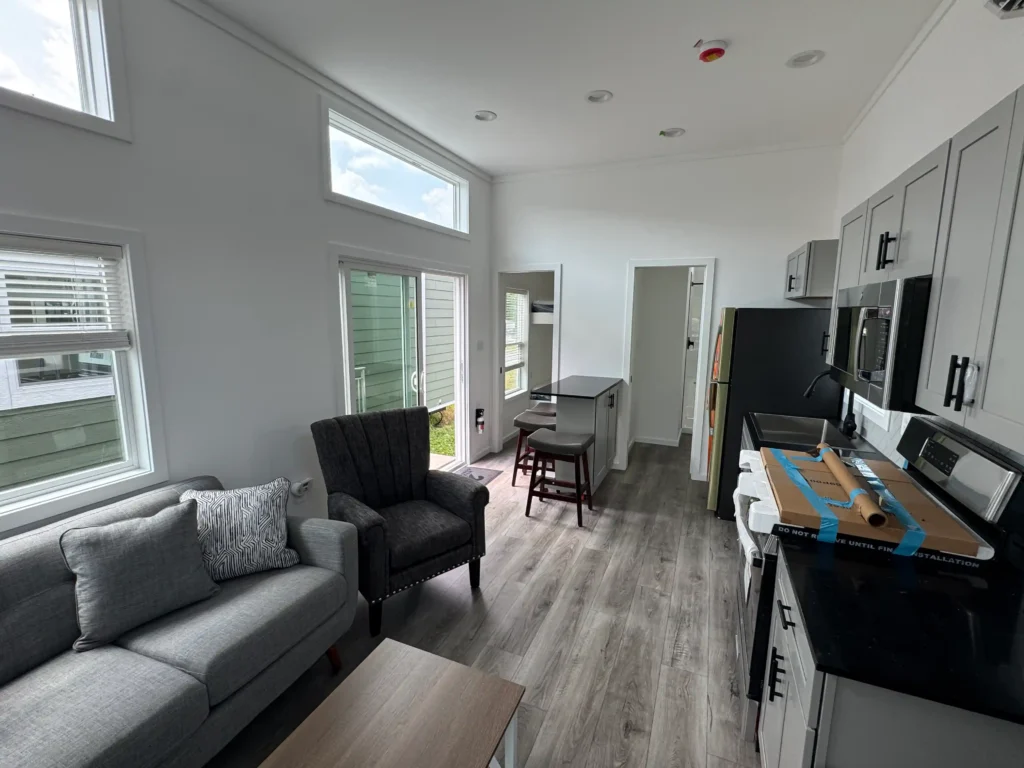 Luxury park model kitchen featuring full-size stainless steel appliances, dark countertops, and a breakfast bar.