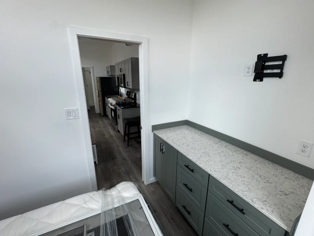 Pillar Cabins park model master suite layout with a queen bed frame and built-in vanity dresser space.