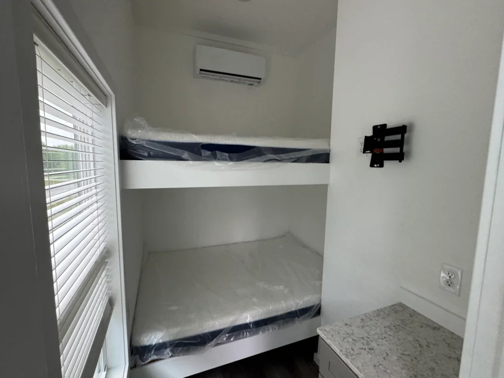 Cozy second bedroom configuration with built-in bunks in a premium park model cabin.
