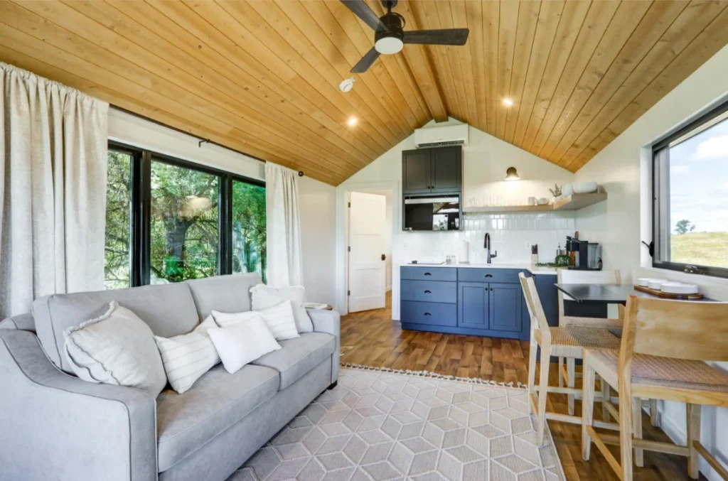 Open concept living room and kitchen interior inside a 12ft wide luxury park model tiny home.
