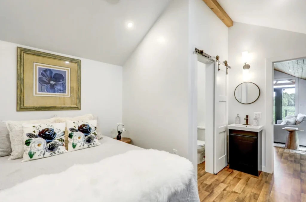 Master bedroom layout in a luxury park model cottage featuring a queen bed and mini split AC unit.
