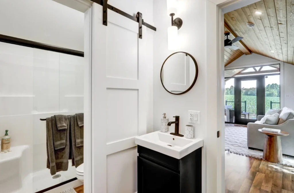 Modern sliding white barn door separating the master bedroom and bathroom in a custom park model.