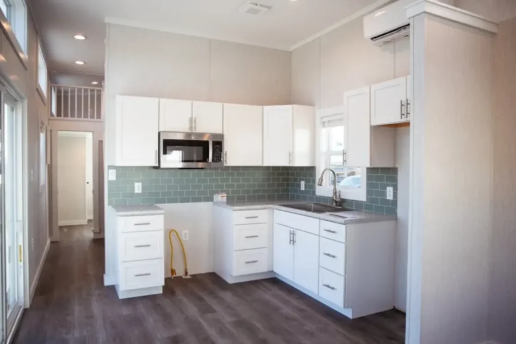 Bright main living floor inside a 399 sq ft park model cabin with cathedral ceilings and wood floors.